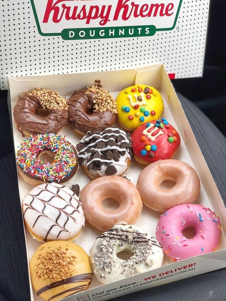 an open krispy kreme doughnut box filled with assorted donuts