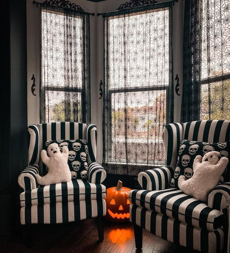 two black and white striped chairs with stuffed animals on them in front of large windows