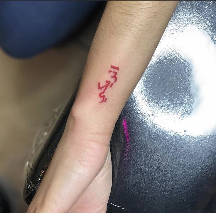 a person with a red ink tattoo on their left arm and the word love written in it