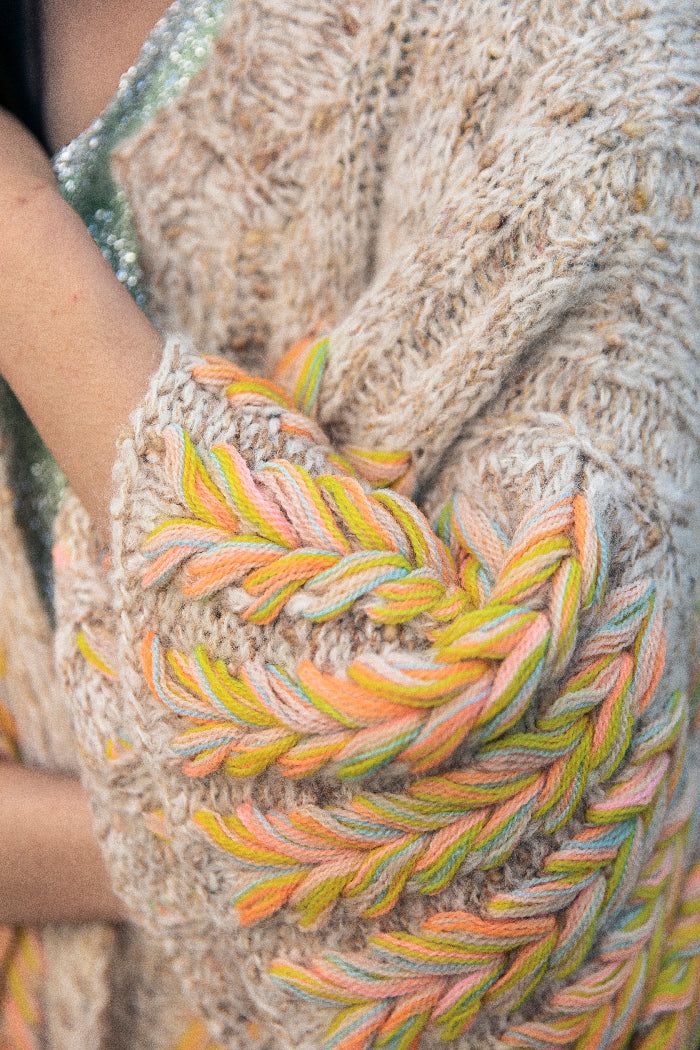 a close up of a person wearing a knitted shawl