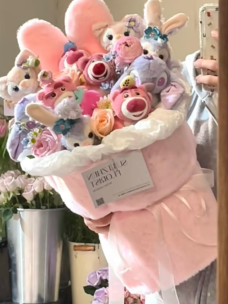 a woman holding a large bouquet of stuffed animals