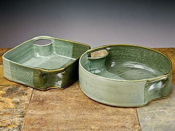 two green dishes sitting on top of a stone counter next to each other and one has a spoon in it