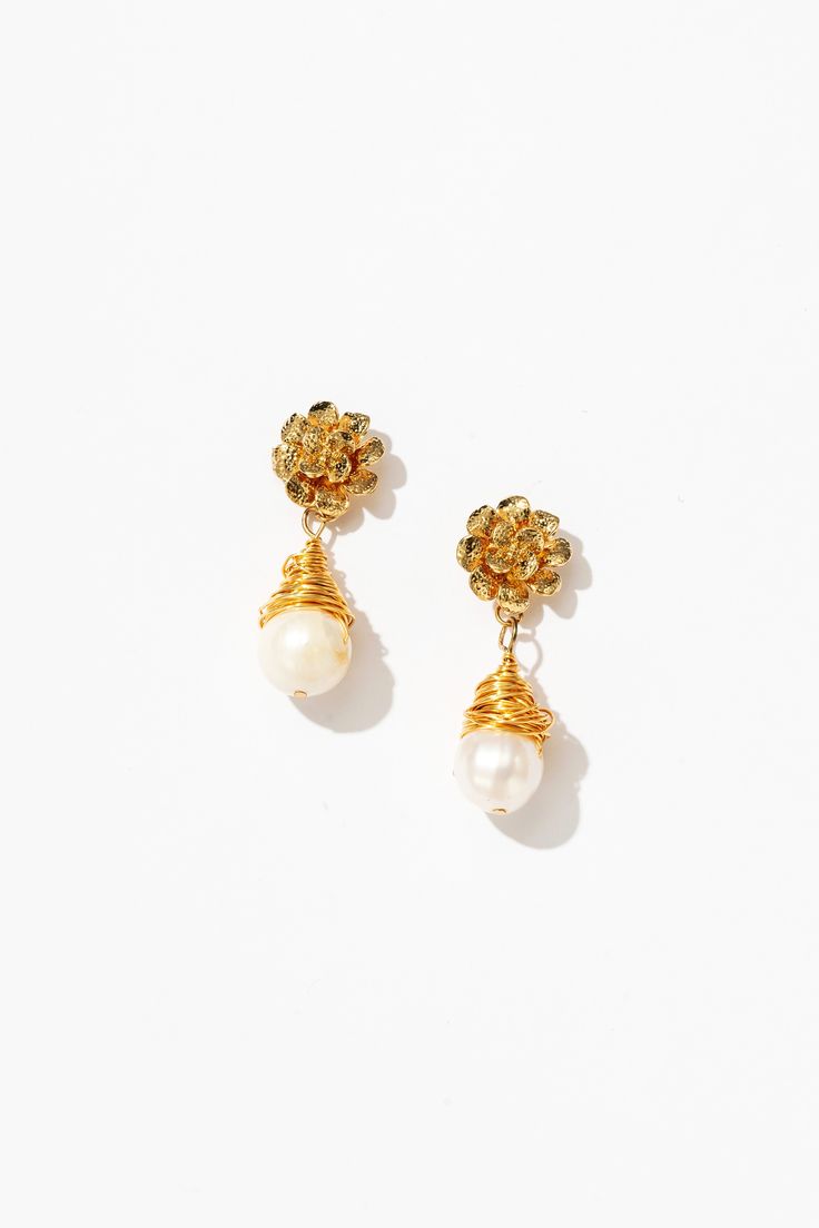 With a mesmerizing blend of contemporary flair and timeless allure, the Cleo Wrapped Pearl Drop Earrings are a true embodiment of sophistication. Each pearl is embraced by delicate gold tendrils, crafted with artisanal precision. These earrings are perfect for elevating casual-chic outfits or adding a hint of glamour to formal attire. Handmade with sustainability in mind, they offer a guilt-free indulgence in luxury, making them an essential accessory for every modern muse. Elegant Brass Flower Earrings As Gift, Elegant Brass Earrings For Celebration, Elegant Gold Wire Wrapped Jewelry, Elegant Wire Wrapped Drop Earrings, Elegant Wire Wrapped Dangle Earrings, Delicate Yellow Gold Earrings For Everyday Elegance, Elegant Brass Bridal Earrings For Celebration, Elegant Brass Flower Earrings For Wedding, Graceful Gold Dangle Earrings