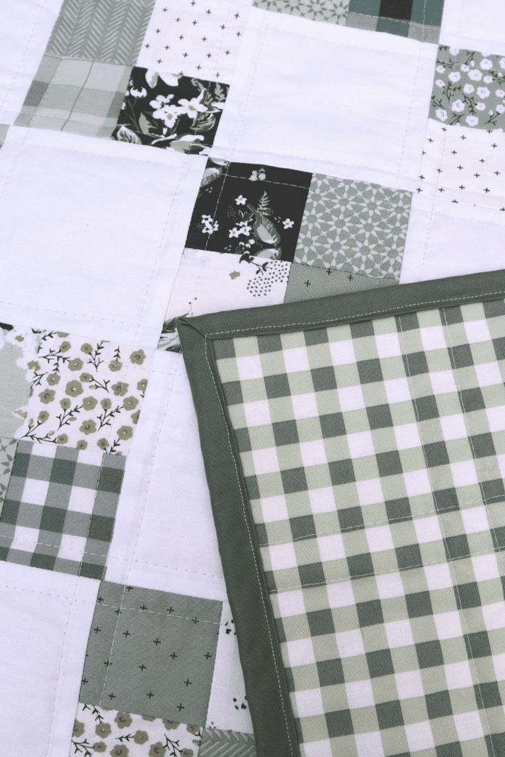 a close up of a patchwork quilt with green and white checkered squares on it