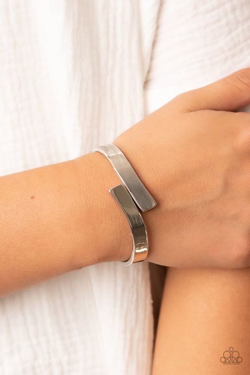 Two oversized silver ribbons delicately overlap across the center of the wrist, creating a stylish and stackable bangle-like cuff. Features a hinged closure. Sold as one individual bracelet. Affordable Adjustable Modern Cuff Bracelet, Cat Eye Jewelry, Gray Bracelet, Yellow Bracelet, Stackable Bangles, Brown Bracelet, Purple Bracelet, Mixed Metal Jewelry, Printed Jewelry