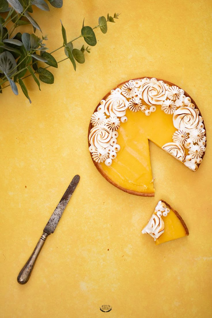 a piece of cheese cake sitting on top of a yellow table next to a knife