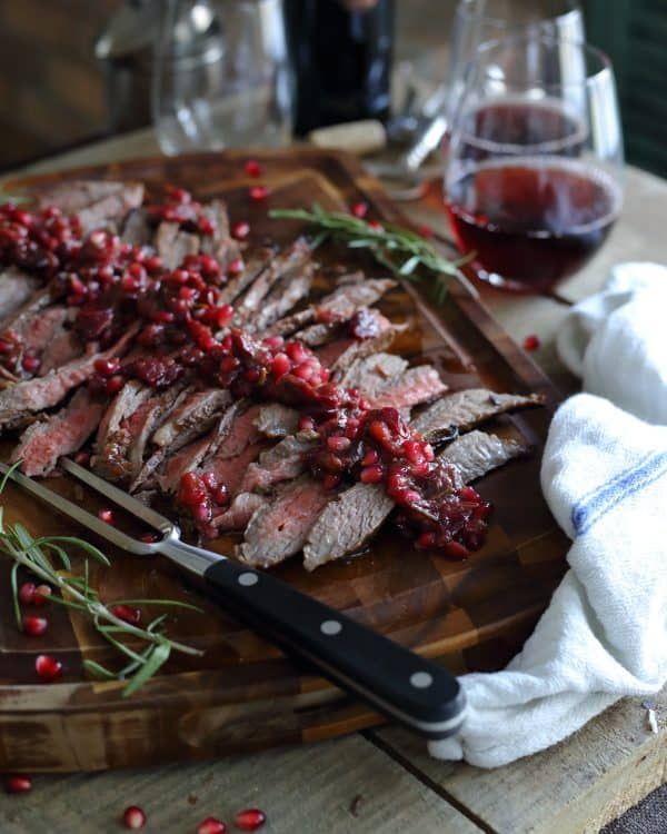 sliced meat with cranberry sauce on a cutting board