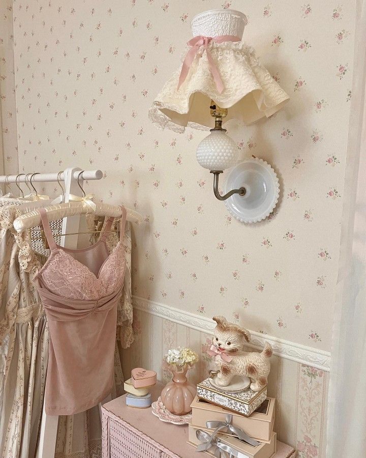 there is a pink dresser and lamp in this room with wallpapers on the walls