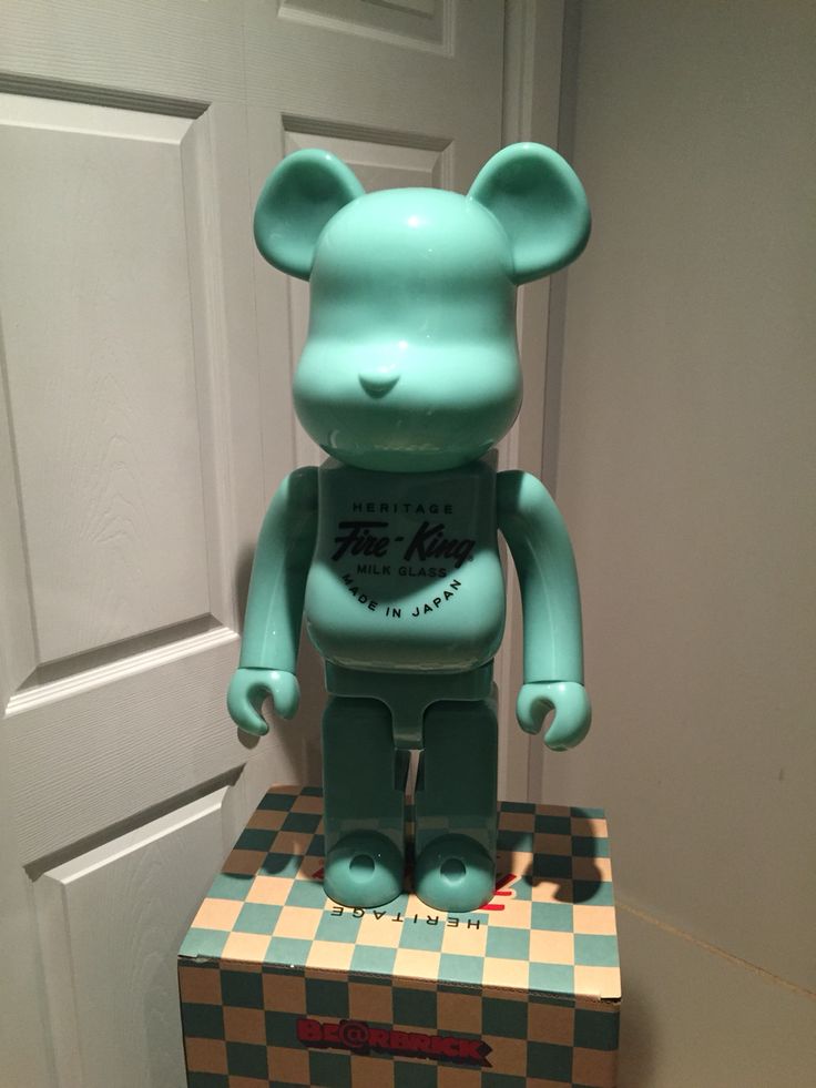 a blue bear statue sitting on top of a checkerboard box in front of a door