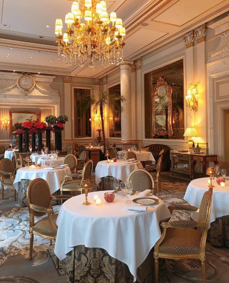 a fancy dining room with chandeliers and white tablecloths