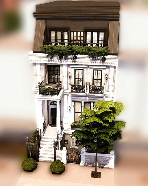 a large white house with balconies on the second floor and trees in front