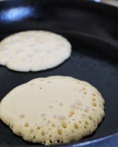 two pancakes frying in a pan on the stove