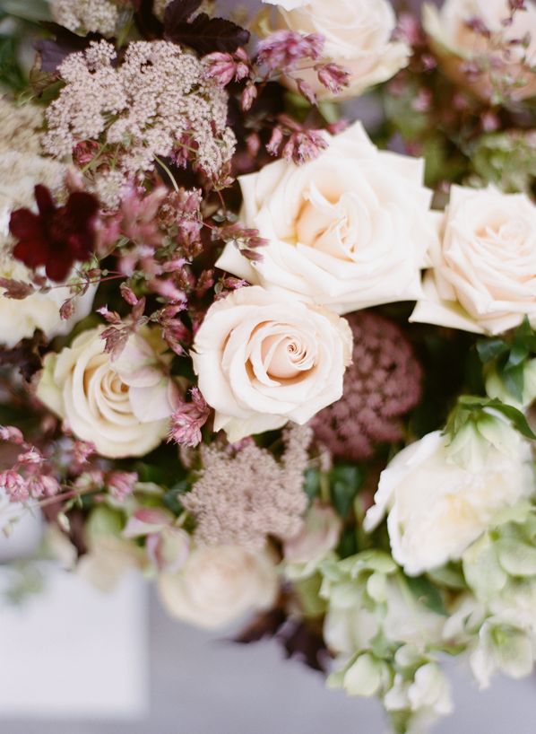 a bouquet of white and pink flowers with greenery in the center is displayed on a table