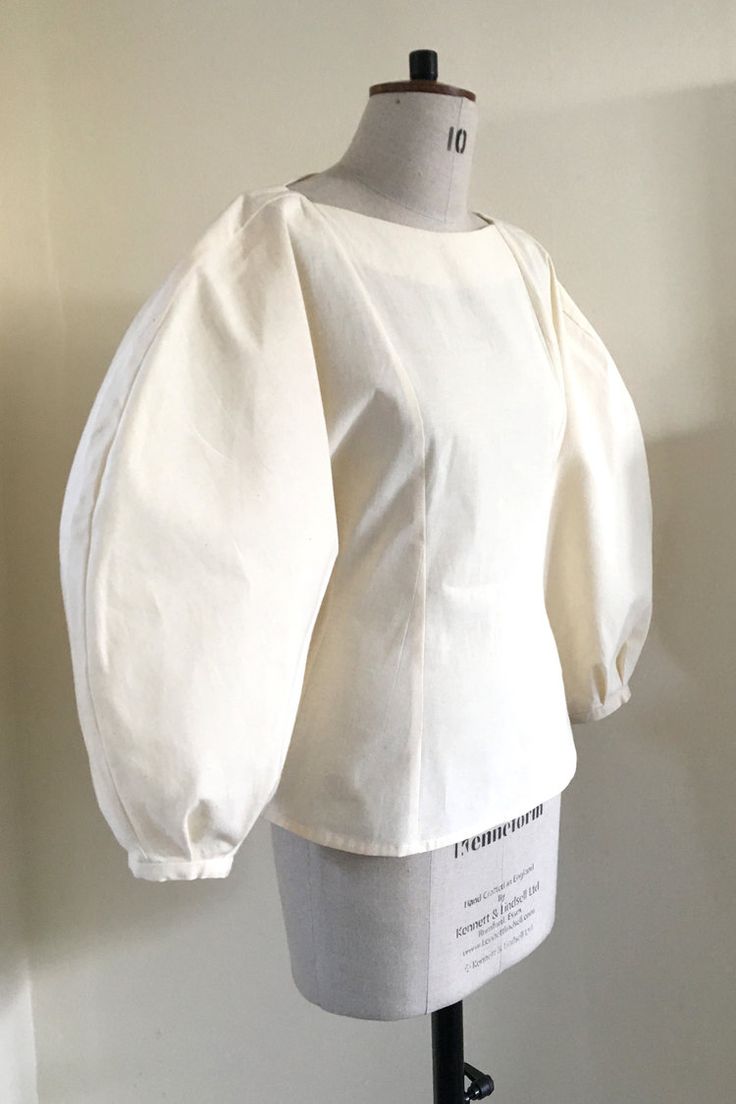 a mannequin wearing a white blouse with puffy sleeves