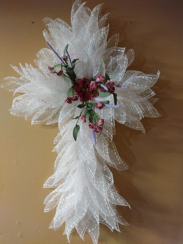 a white flower with pink flowers and green leaves on top of a yellow tablecloth