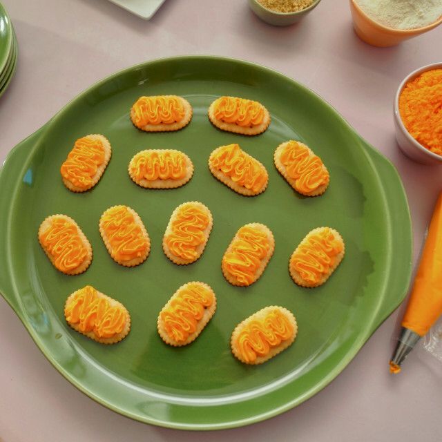 there are many small cookies on the green plate next to some measuring cups and utensils