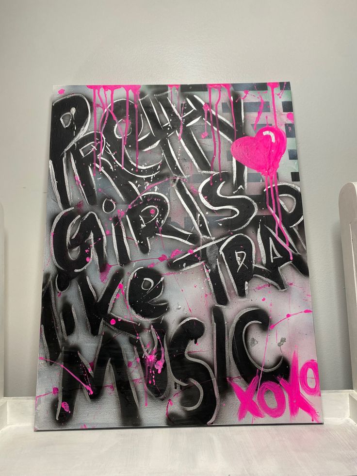 a piece of art that is on top of a white shelf and has pink spray paint all over it