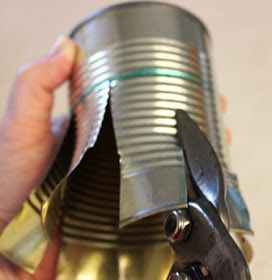 a person holding a can with some metal parts on it's side and the bottom part missing