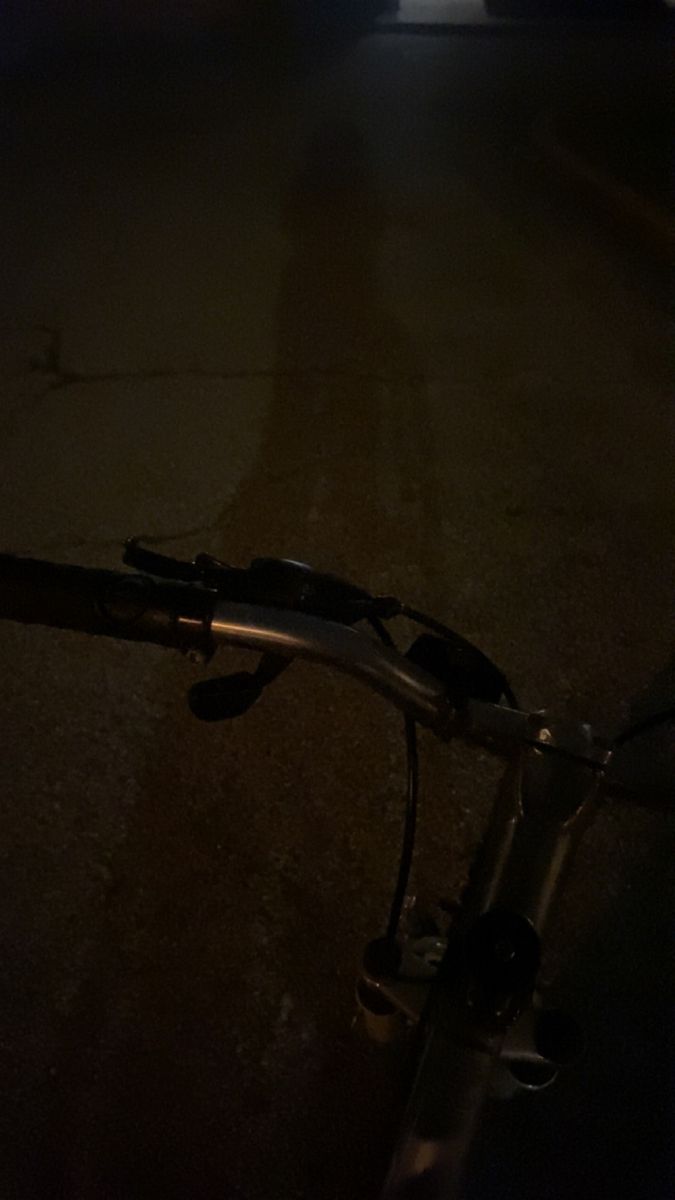 a bicycle is parked on the side of the road at night