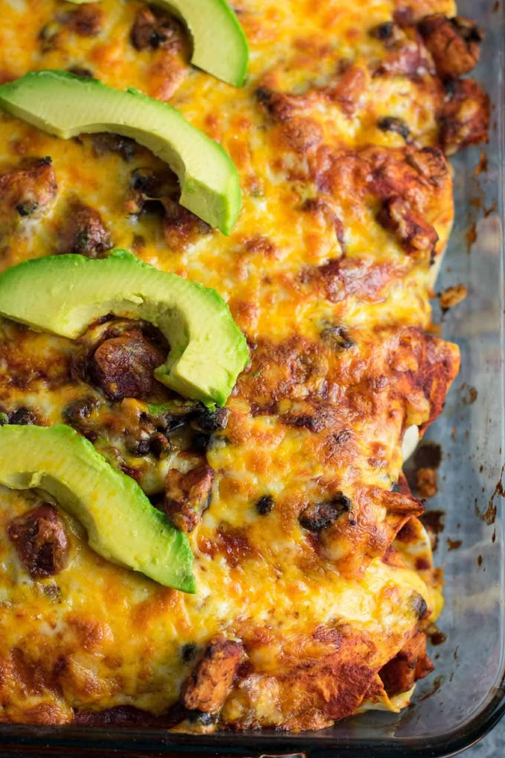 an enchilada casserole with meat and avocado on top