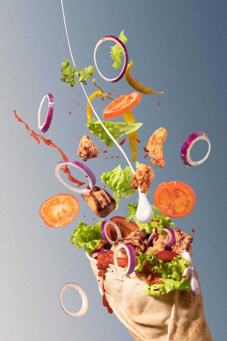 an image of food being thrown into the air by a person's hand and flying through the air