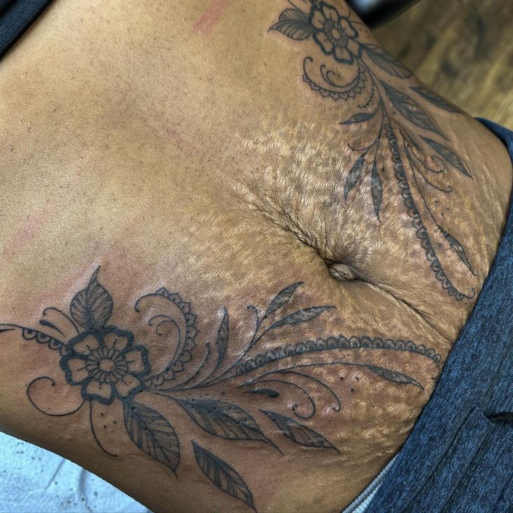 a close up of a person's stomach with tattoos on it