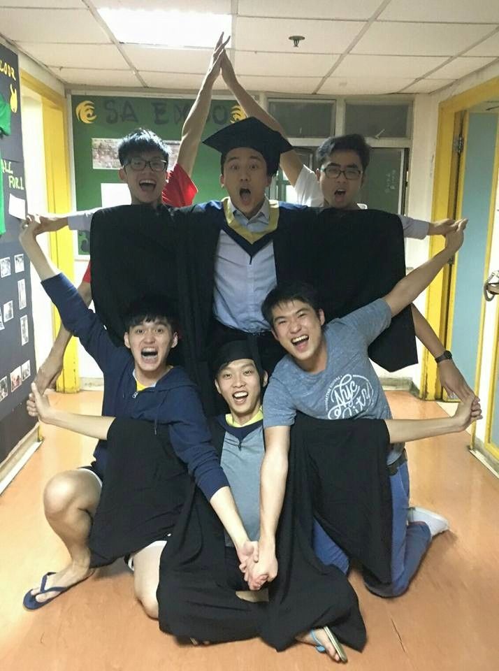 a group of people sitting on top of each other in front of a blackboard