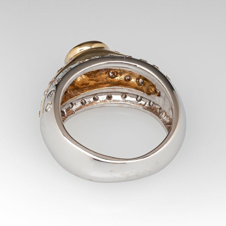 two tone gold and silver ring with diamonds on the sides, set against a white background