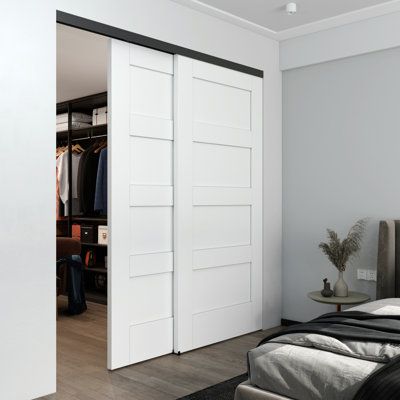 a bedroom with a bed, closet and two doors open to reveal a walk - in closet