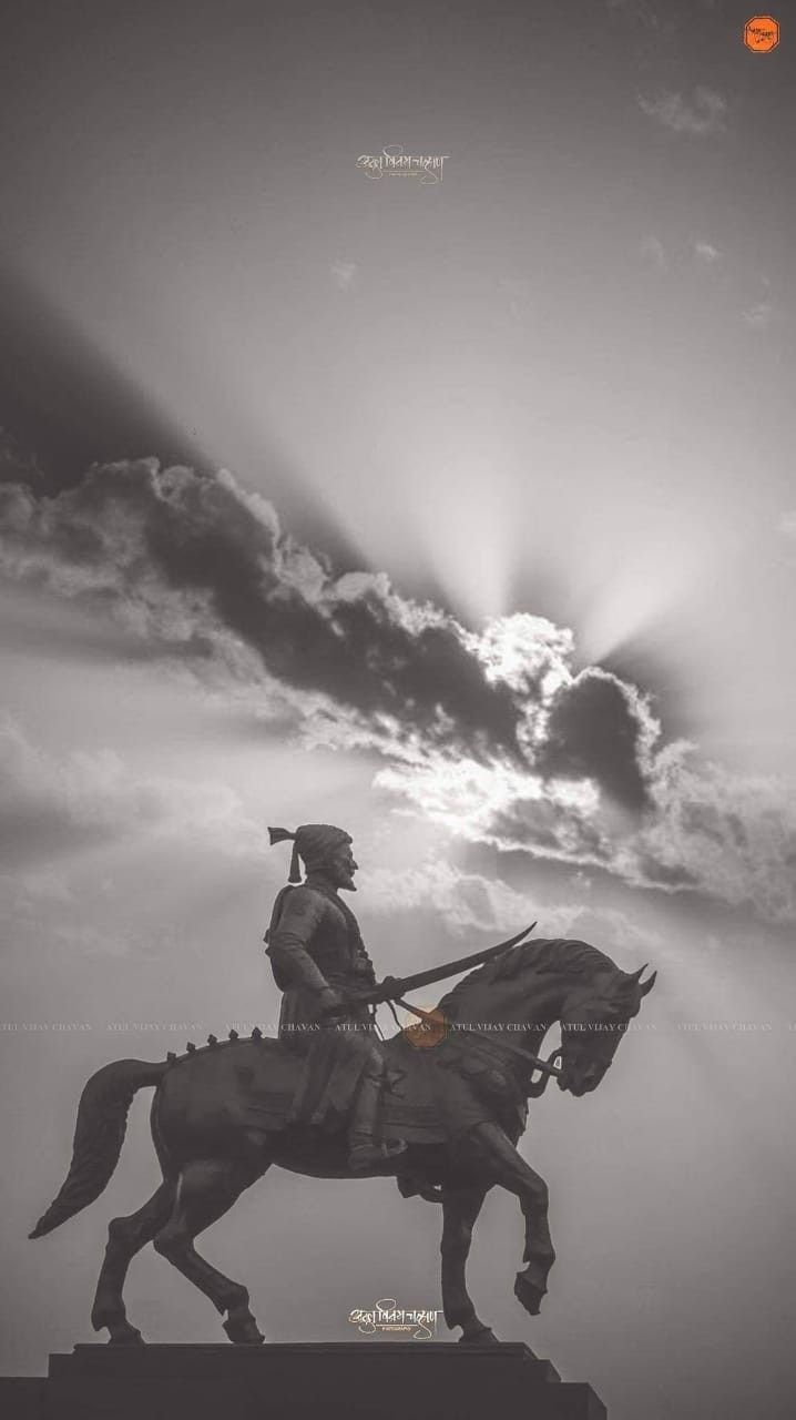 a statue of a man riding on the back of a horse under a cloudy sky