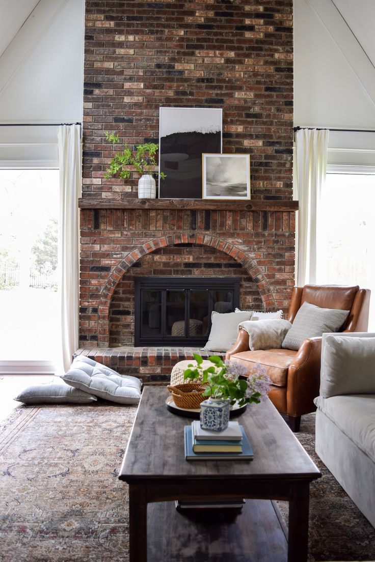 a living room with a brick fireplace and couches