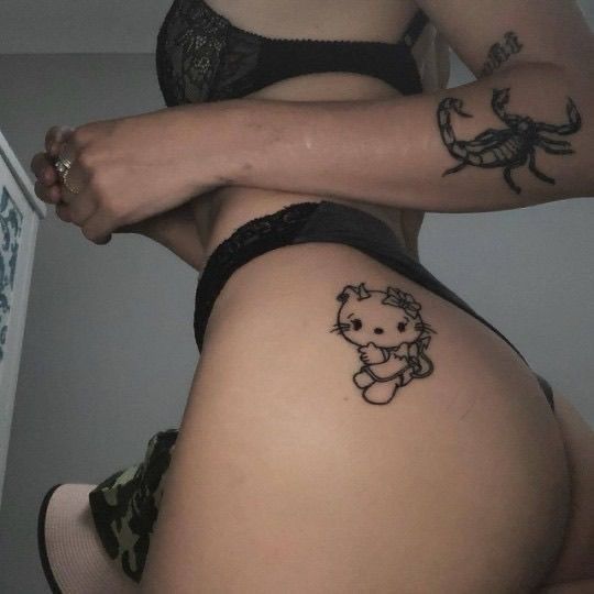 a woman with two tattoos on her stomach and one has a teddy bear in the middle