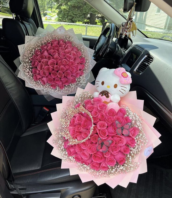 two hello kitty bouquets sitting in the back seat of a car with pink roses