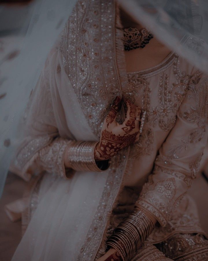 a woman wearing a bridal outfit and holding her hands together