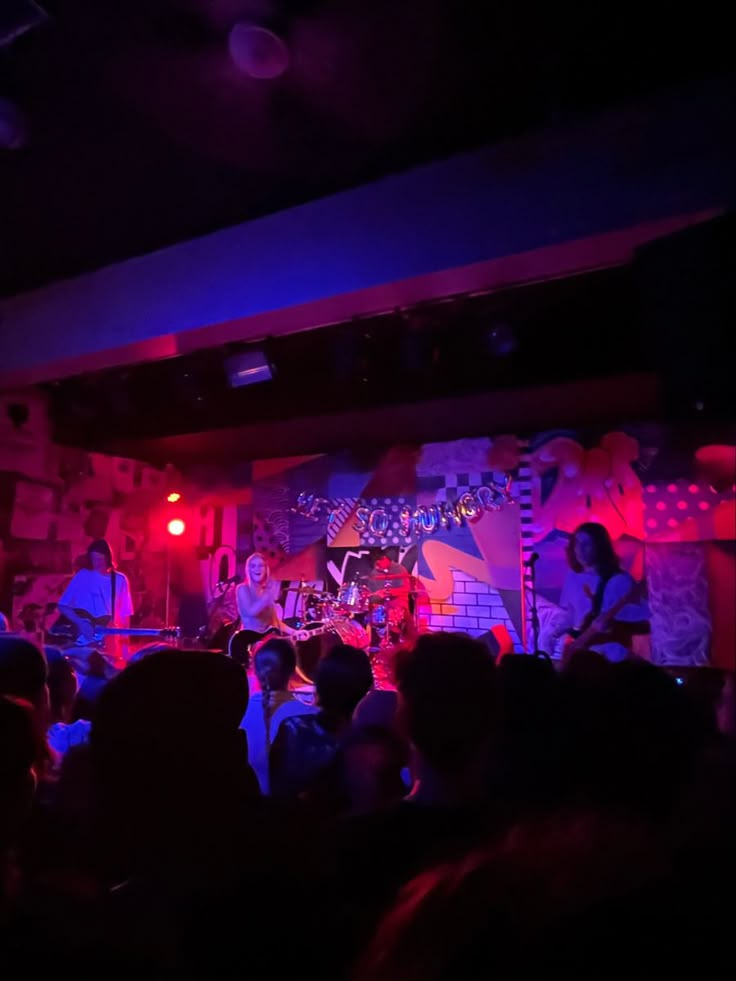 a group of people that are standing in front of a stage with lights on it