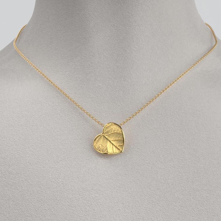 Capture nature's beauty with our dainty Italian 14k or 18k gold heart pendant and chain. Exquisitely small and adorned with a delicate leaf motif, this pendant is a wearable piece of art that symbolizes love and connection. Meticulously crafted in Italy, the intricate details and fine craftsmanship make this tiny heart pendant a cherished expression of elegance and nature's grace. 14k or 18k gold 16mm high 15mm large 18k Rolò chain chain length 45cm chain thickness 1.5mm designed and crafted in