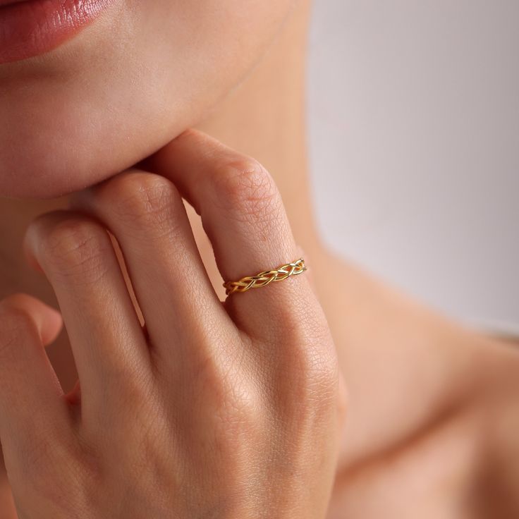 a close up of a person wearing a ring with a gold chain on it's finger