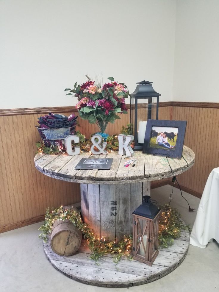 a round table with flowers and pictures on it next to a vase filled with flowers