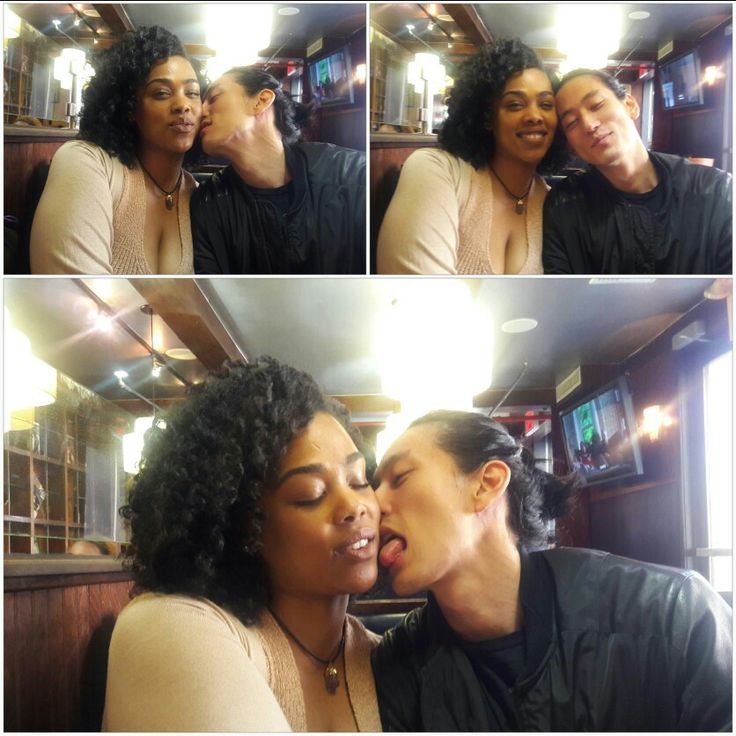 two women are kissing each other in front of a mirror and another woman has her face close to the camera