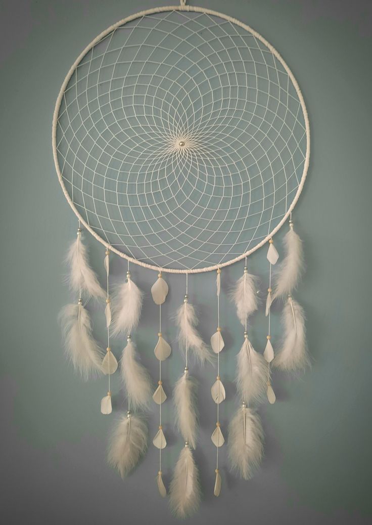 a white dream catcher hanging on the wall