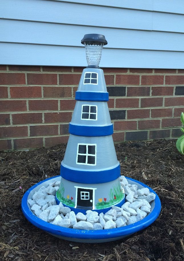 a blue and white plastic cone shaped house on top of rocks