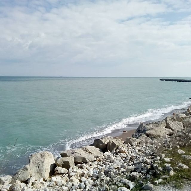 there is a rocky beach next to the ocean