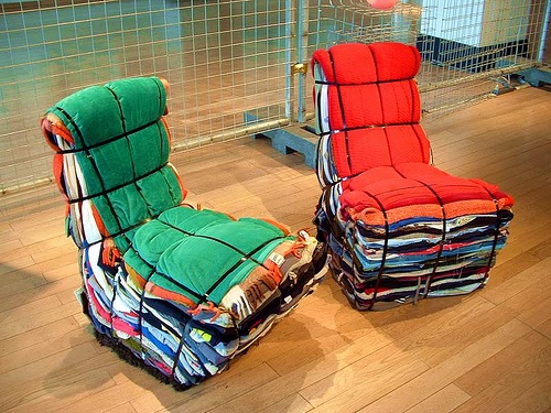 two chairs made out of cloths sitting on top of a wooden floor next to each other