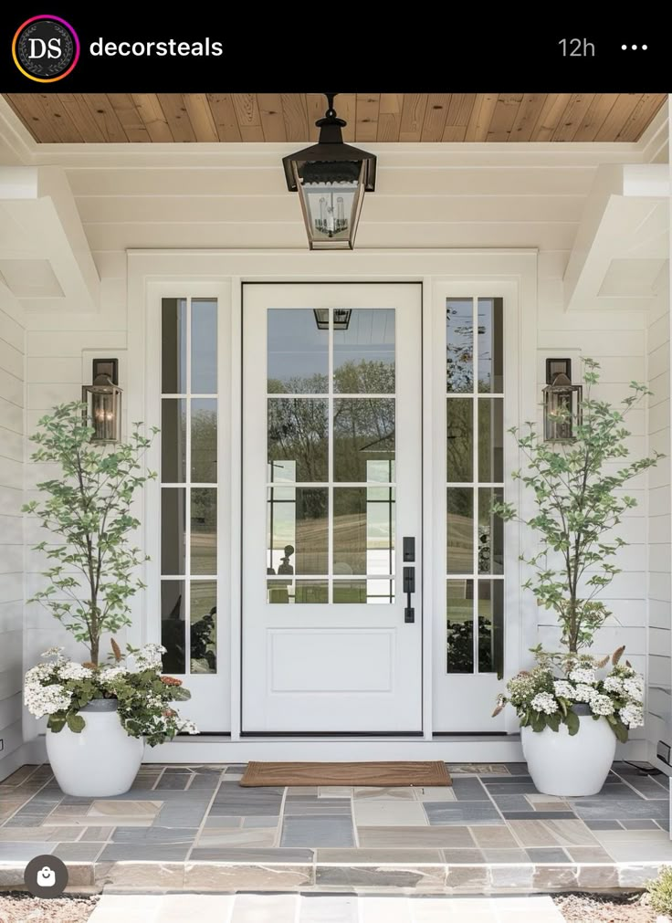 a white front door with two planters on each side