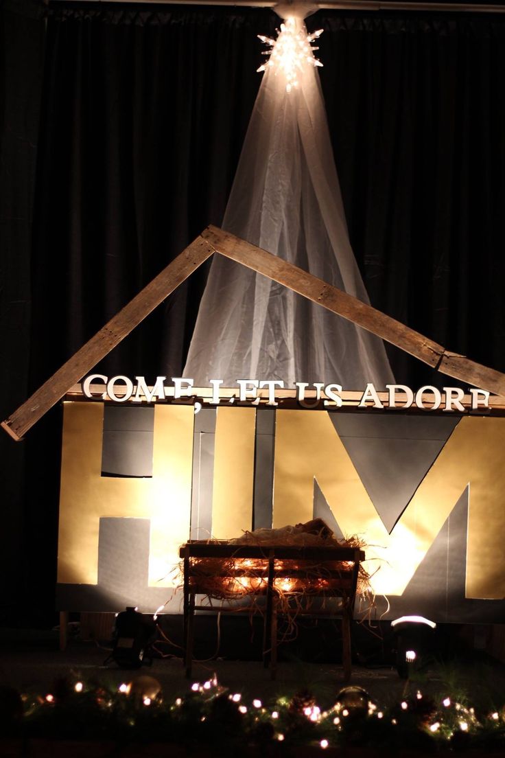 a nativity scene with the word hum written on it and lights shining from above