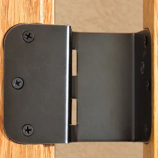 a close up view of a door hinge with two black knobs on it