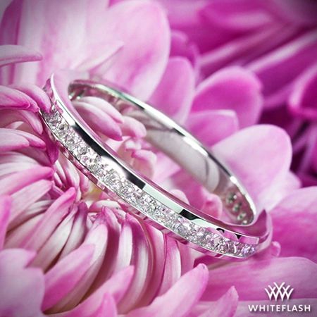 two wedding rings sitting on top of pink flowers