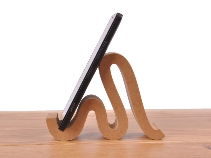 a wooden tablet holder with a cell phone on it's back and an upside down stand