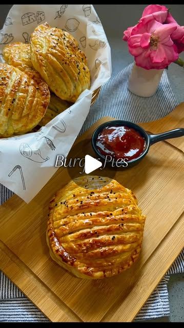 some food is sitting on a cutting board next to a vase with flowers in it