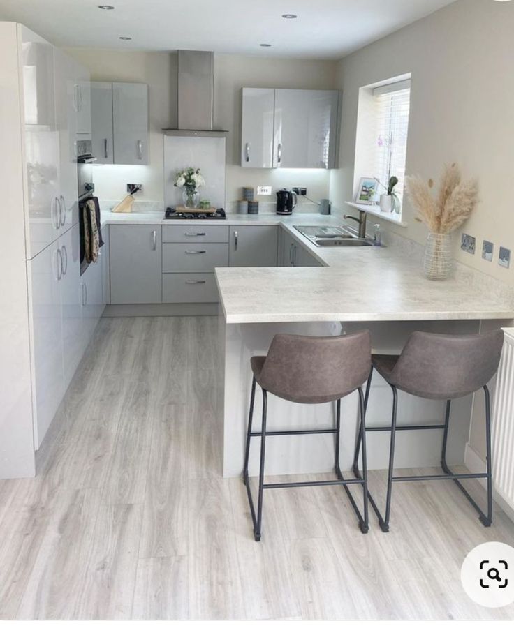 a kitchen with two stools next to an island